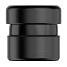 A matte black, cylindrical Flower Mill 2" Next Gen Premium Grinder with rounded edges and a layered design, featuring a medium mill plate, is shown against a white background.