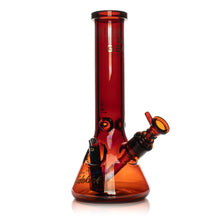 The Gear Premium 12" Sidekick (Beaker) Water Pipe is a translucent amber borosilicate glass bong with a wide base, angled downstem, 14mm bowl, black accents, and measurement markings along the neck.