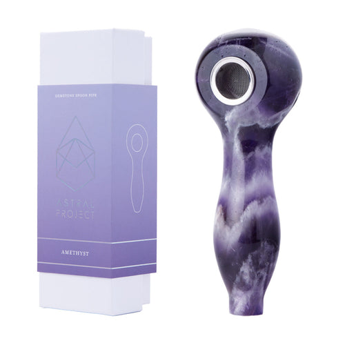 A polished amethyst Gemstone Spoon Pipe with a rounded bowl sits beside its purple and white Astral Project box labeled 