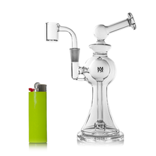The MJ Arsenal Apollo Mini Dab Rig, crafted from clear borosilicate glass with a side arm and angled mouthpiece, is shown next to a green lighter on a white background for size comparison.