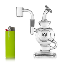 The MJ Arsenal Atlas Mini Dab Rig, a small clear borosilicate glass rig with a round chamber and curved neck, is shown next to a lime green and silver lighter on a white background.