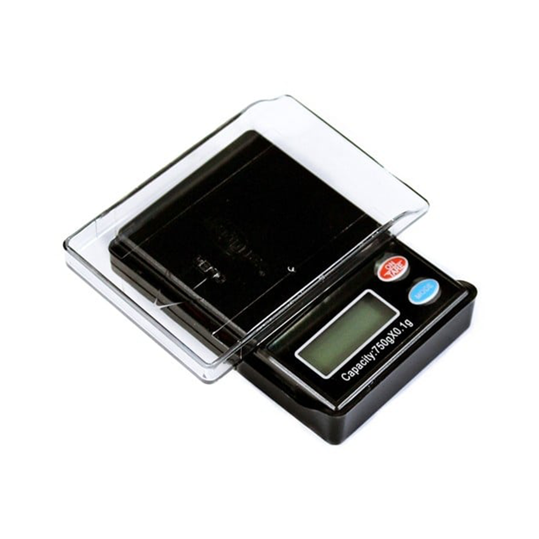 The WeighMax Scales is a compact digital scale featuring a transparent plastic cover, back-lit LCD display, blue and red buttons, and a clearly displayed 750g capacity on the panel.