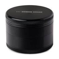 The Human Grade Grinder 1B (2.5") is a black cylindrical aluminum grinder with textured grip edges and "HUMAN GRADE" in silver on the lid. This 4-piece design has a built-in pollen screen and is shown against a white background.