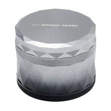 A 2.5" silver, faceted aluminum grinder with a textured grip and "HUMAN GRADE" printed on the lid, named Human Grade Grinder 7F.