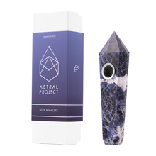 A Gemstone Pipe made from blue sodalite with a replaceable mesh bowl stands upright beside its white and purple Astral Project box labeled "Gemstone Pipe Blue Sodalite.