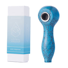 A blue turquoise Gemstone Spoon Pipe with a marbled pattern and metal bowl stands upright beside its white and blue Astral Project packaging, crafted from healing gemstones for a unique smoking experience.