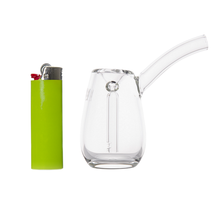 A green cigarette lighter stands upright beside an MJ Arsenal Bulb Bubbler, a small, transparent borosilicate glass piece with a curved mouthpiece, both set against a white background.