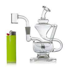 The MJ Arsenal Claude Mini Dab Rig, made of clear glass with a unique design, is shown next to a green and gray lighter on a white background.