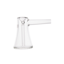 The MJ Arsenal Vulkan Bubbler, made of clear borosilicate glass, features a flared base, cylindrical body, and a straight side spout. It is shown against a white background.