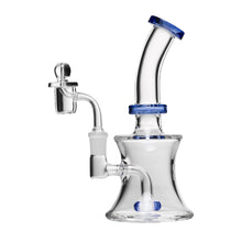 The Human Grade 8" Oil Can Rig is a clear borosilicate glass water pipe with blue accents, a bent neck, round base, and a 14mm quartz bucket bowl piece on the left side.