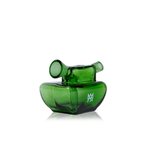 The MJ Arsenal Commander Blunt Bubbler is a small green borosilicate glass smoking pipe with a modern sculptural design and a white logo on its side, shown against a white background.
