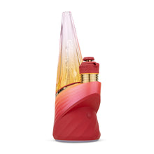 The Puffco New Peak Pro with 3D XL Chamber features a modern, cone-shaped glass with a gold-to-clear gradient, paired with a textured red and gold smart rig base and button, shown on a white background.