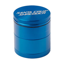 The Santa Cruz Shredder Medium 4-Piece Grinder is a blue, cylindrical, medical-grade herb grinder made from anodized aluminum with ridged edges for grip and the brand name in white on the lid, shown against a white background.