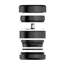 An exploded view of a camera lens displays its black components layered like those of the Flower Mill 2.5" Next Gen Premium Grinder, all separated and aligned vertically against a white background.