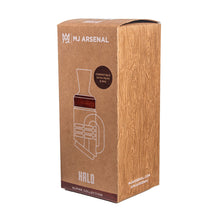 A brown, rectangular MJ Arsenal Alpine Series - Halo Peak Top box with a woodgrain pattern features a white outline of the borosilicate glass top, text noting Peak e-rig compatibility, and the MJ Arsenal logo.