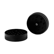 Two BIGFUN! Medium 2pc black metal grinders are shown: one flat, revealing sharp diamond teeth, and one on its side displaying the interior. Both CNC milled grinders have textured edges for secure grip.