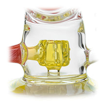 Close-up of the Calibear Loopsicle Recycler Dab Rig, crafted from borosilicate glass with a yellow geometric center and red side accents, reflected on a glossy surface.