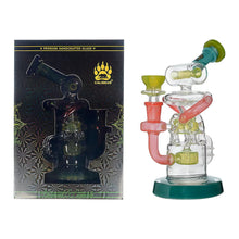 A Calibear Gusher Recycler Dual Percolator Dab Rig with colorful accents sits beside its packaging, which displays a gold logo, intricate patterns, and the text "Premium Handcrafted Glass" and "Calibear" on a dark background.