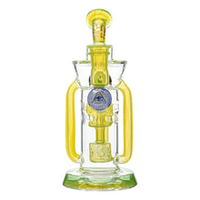 The Calibear Supercycler Recycler Dab Rig is clear and yellow with a round base, side handles, and a blue-white eye symbol on the front. It features intricate glasswork and an advanced recycler system.