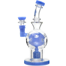 The Calibear Exosphere Seed Of Life Dab Rig is a clear borosilicate glass piece with blue accents on the base, mouthpiece, and bowl. It features a spherical midsection and an intricate Seed of Life percolator design.