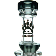 A close-up of the Calibear Exosphere Seed Of Life Dab Rig, made from clear borosilicate glass, featuring a black bear paw print logo and “CALIBEAR” beneath it. Thick glass accents at the top and bottom add durability and style.