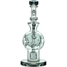 The Calibear Exosphere Seed Of Life Dab Rig is a clear borosilicate glass piece featuring a round chamber, intricate internal design, flat base, Seed of Life percolator, and bear paw logo near the mouthpiece for style and smooth hits.