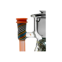 Close-up of the Calibear WigWag Seed Of Life Percolator Incycler Dab Rig, showcasing its multicolored wig wag design and orange rim on a clear glass chamber with intricate details, set against a white background.