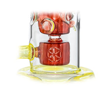 Close-up of the Calibear Seed Of Life Swiss Incycler Dab Rig, showcasing vibrant red and yellow accents with intricate circular patterns and geometric engravings on its central chamber.