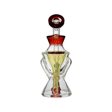 The Calibear Hourglass Marble Adorned Recycler Dab Rig features clear glass, an hourglass marble shape, red accents on the top and middle, yellow liquid inside, two side handles, and a round stopper—resembling a stylish perfume bottle.