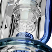 Close-up of the Calibear Pillar Flower Of Life Klein Bong, showcasing intricate textures, a cylindrical section with raised ovals, and blue-tinted glass elements inspired by the Flower of Life percolator design.