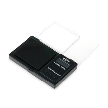 The WeighMax Scales features a black platform, back-lit LCD display, control buttons, and a clear plastic lid. This compact digital scale provides precise measurements with a maximum capacity of 750g.