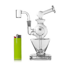The MJ Arsenal Gemini Mini Dab Rig, made of clear borosilicate glass with a spherical chamber and angled mouthpiece, is shown beside a bright green lighter—ideal for portable dabbing sessions.