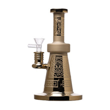 The Human Grade Aztec (Sandblasted) Glass Water Pipe features gold and black borosilicate glass with geometric and tribal patterns, a clear glass bowl, and a wide, stable base.