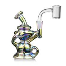 The MJ Arsenal Hydra Mini Dab Rig, featuring a colorful iridescent finish, curved neck, intricate Klein recycler design, and a clear quartz banger for vaping concentrates, is displayed against a white background.