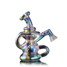 The MJ Arsenal Hydra Vape Edition is an iridescent glass mini dab rig with a curved mouthpiece, angled neck, artistic design, handle, and logo on the body, shown against a white background.