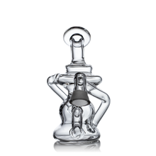 The MJ Arsenal Hydra Vape Edition is a clear glass mini dab rig with a complex, twisted design and gray bowl, offering splash resistance as a bubbler. Shown against a white background.