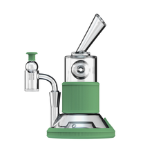 The Softglass Tandem Rig Kit is a sleek, modern dab rig with a cylindrical borosilicate glass body, green platinum-cured silicone accents, angled mouthpiece, and side arm with a small chamber for functional style.