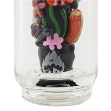 A close-up of the Empire Glass Works Save the Seas Peak Top shows intricate coral and plant-themed glass art, a silver castle and flame emblem on the base, and glow-in-the-dark accents.