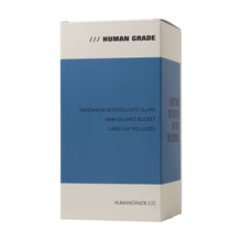 A rectangular box labeled Human Grade in blue and beige promotes the Human Grade Mushroom Globe Glass Rig. Highlights: Handmade Borosilicate Glass, 14mm Quartz Bucket, Mushroom Globe Dab Rig, Carb Cap Included. Website: HUMANGRADE.CO.