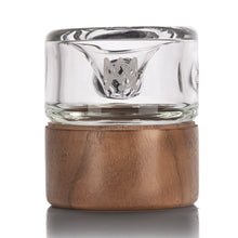 Clear glass shot glass with wooden base on a white background