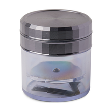 The Human Grade Storage Grinder 1A (2.5") is a clear, small cylindrical container with a metallic screw-on lid, containing a round aluminum grinder disc and a small black brush inside.
