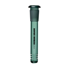 The Human Grade Color Downstem (14MM) is a transparent green glass tube with a rubber stopper and "HUMAN GRADE" printed vertically. It includes metal clips at the base and is designed as a downstem replacement for 14mm water pipes.