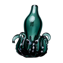 The Octopus Carb Cap features a green borosilicate glass bottle with smooth curves atop a sculpted black glass base resembling curled tentacles with white spots and a small abstract symbol on the front, perfect for dab accessories.
