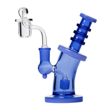 The Human Grade 6.25" Bent Neck Dab Rig is a blue borosilicate glass water pipe with a cylindrical base, ringed neck, angled mouthpiece, and clear bowl and downstem. It fits a 14mm quartz bucket for optimal dabbing.