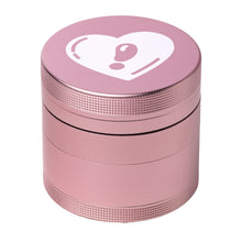 The BIGFUN! Medium Grinders is a pink cylindrical aluminum grinder with a ridged texture and a white heart with an exclamation mark on the lid, shown against a white background.