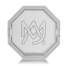 The MJ Arsenal Pegasus Ashtray is a clear, octagonal luxury piece featuring an etched overlapping M and A logo at the center and two grooves for holding cigarettes, offering both elegance and functionality.