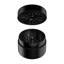 The Flower Mill 2.5" Next Gen Premium Grinder is a black, two-piece design shown with the top section hovering above the bottom, exposing its sharp mill plates and multiple holes for efficient herb filtering.