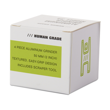 The Human Grade Grinder 3A (2" 4-Piece) comes in a white, green-accented box labeled HUMAN GRADE, featuring a textured, easy-grip aluminum design, scraper tool, and minimalist icon.