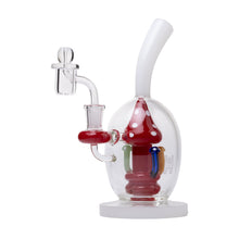 The Human Grade Mushroom Globe Glass Rig is a clear borosilicate water pipe with a white base and mouthpiece, featuring a red and white mushroom centerpiece inside and a side arm for the 14mm quartz bucket attachment.