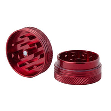 The 2 Piece Flat Grinder is shown in red, with one half lying flat to reveal sharp interior teeth and the other upright, highlighting matching teeth and grip-friendly textured edges. Available in multiple colors.